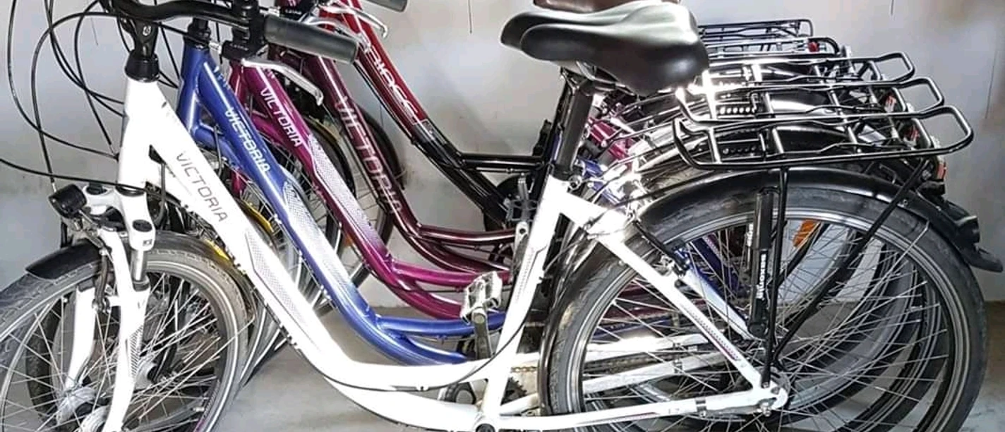 Fahrradverleih Nülle Mehrere Stadtfahrräder stehen geordnet nebeneinander auf einem Betonboden in einem Fahrradverleih.