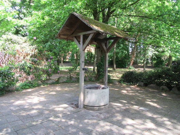 Grillplatz am Schützenhaus Mardorf Grillplatz mit gepflegtem Holzunterstand und Sitzbereich, umgeben von üppiger, grüner Vegetation.