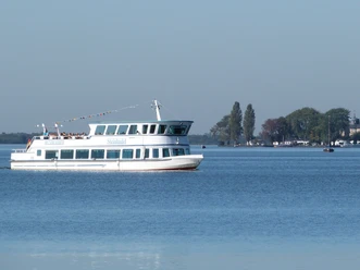 Personenschiff Steinhude Das Bild zeigt ein weißes Passagierschiff namens "Steinhude" auf dem Steinhuder Meer mit blauen Himmel im Hintergrund.