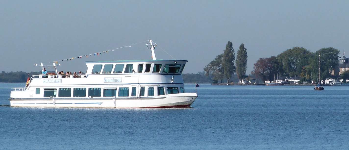 Personenschiff Steinhude Das Bild zeigt ein weißes Passagierschiff namens "Steinhude" auf dem Steinhuder Meer mit blauen Himmel im Hintergrund.