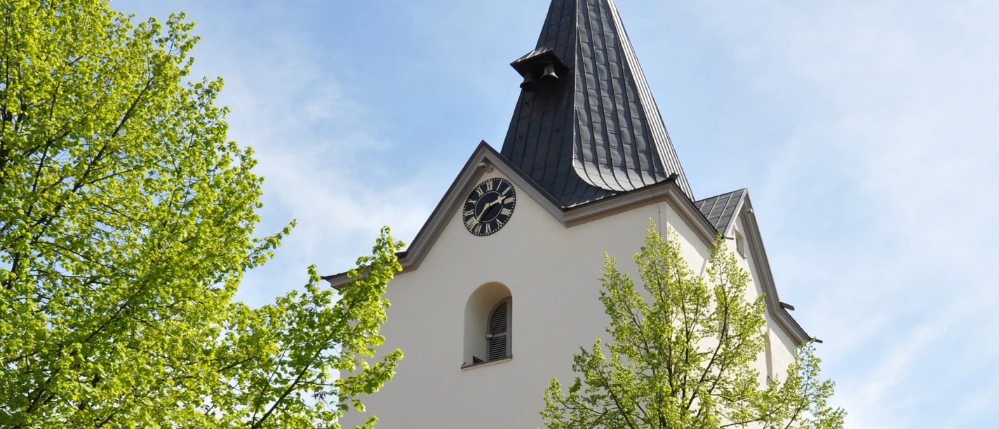 Liebfrauenkirche Gothische Kirche mit spitzem Turm vor blauem Himmel, umgeben von grünen Bäumen und Kopfsteinpflaster.
