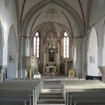 Altar Liebfrauenkirche Blick in eine helle Kirche mit weißem Gewölbe, hölzernen Bänken und kunstvollem Altarbild.