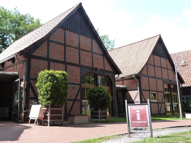 Half-timbered tourist information center in Steinhude: Inviting brick building with green surroundings.
