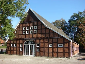 Heimatmuseum Langen Historisches Fachwerkhaus mit Backsteinfassade und Inschrift von 1851, umgeben von Bäumen.