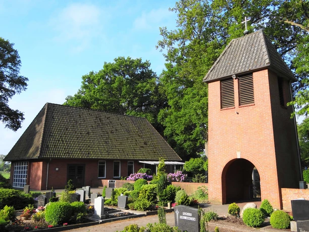 Kapelle Nordloh Kapelle Nordloh: Historische Backsteinkapelle mit markantem Turm, umgeben von gepflegten Gräbern.