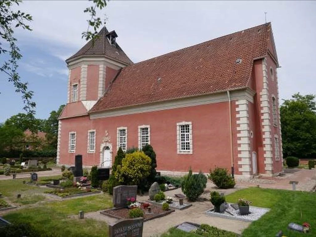 Schloss Ricklingen Kirche Historische Kirche aus rotem Backstein mit markantem Turm, umgeben von gepflegtem Friedhof.