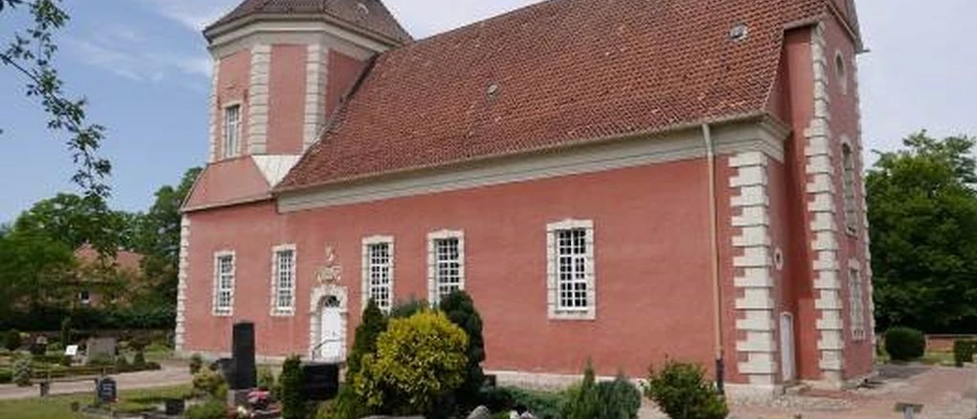 Schloss Ricklingen Kirche Historische Kirche aus rotem Backstein mit markantem Turm, umgeben von gepflegtem Friedhof.