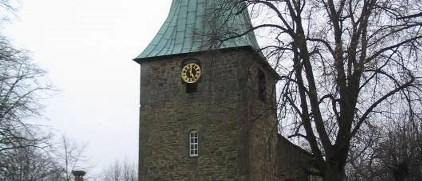 Kirche Luthe Historische Kirche in Luthe, Niedersachsen mit hohem, spitzen Turm und steinerner Fassade.