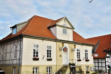 Altes Rathaus Ein altes Gebäude mit rotem Ziegeldach und weißen, symmetrischen Fassadenfenstern steht majestätisch.