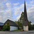 Evangelische Kirche Paderborn-Elsen Evangelische Kirche Paderborn-Elsen mit modernem spitzen Turm und umliegenden Bäumen an einem bewölkten Tag.