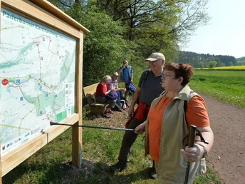 Informationstafel "Paderborner Karstrundweg" im Ellerbachtal Wanderer studieren intensiv die Route des Paderborner Karstrundwegs an einer Informationstafel.