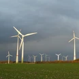 Windkraftanlagen auf dem Holterfeld Windkraftanlagen auf grüner Wiese unter bewölktem Himmel mit mehreren Windrädern im Hintergrund.