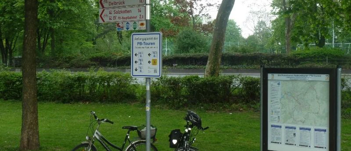 Zwei Fahrräder stehen am Startpunkt der Paderborn-Touren am Maspernplatz neben Wegweisern und Infotafel.