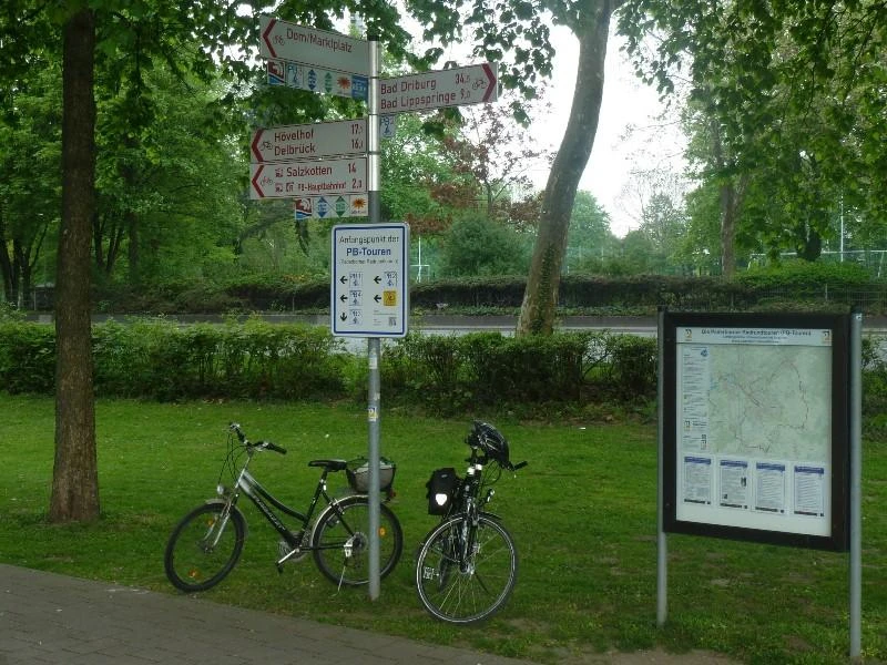Zwei Fahrräder stehen am Startpunkt der Paderborn-Touren am Maspernplatz neben Wegweisern und Infotafel.