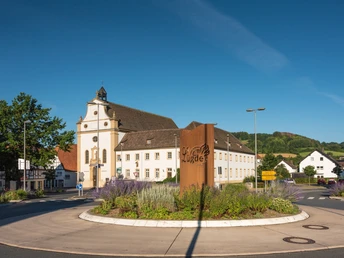 Ehemaliges Franziskanerkloster in Lügde Ehemaliges Franziskanerkloster in Lügde mit prächtiger Fassade, neoklassizistischem Stil umgeben von einer modernen Verkehrsinsel.