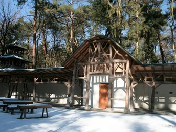 Historische Holz-Liegehalle im Kurpark Bad Lippspringe, eingebettet in einen winterlichen Wald.