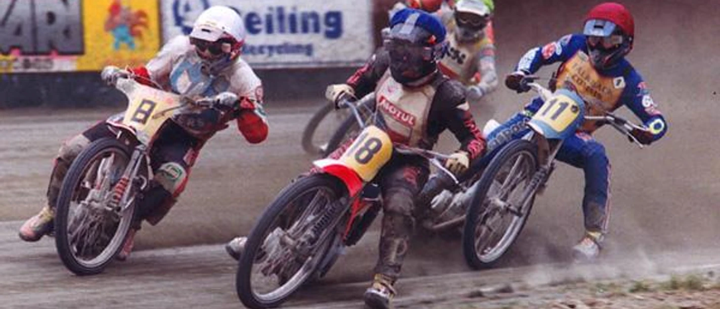 Spannende Motorrad-Sandbahnrennen im Emstalstadion des MSC Motorsportclubs Harsewinkel Drei Speedway-Fahrer in voller Schutzausrüstung rasen in einem engen Rennen auf einer Schotterstrecke.