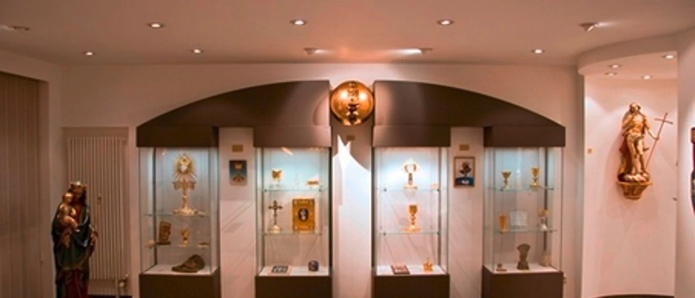 Moderne Ausstellung religiöser Kunstobjekte mit Beleuchtung und Vitrinen im Ars Sacrale Museum.