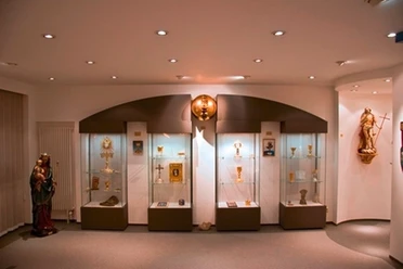 Ars Sacrale - Innenansicht Moderne Ausstellung religiöser Kunstobjekte mit Beleuchtung und Vitrinen im Ars Sacrale Museum.