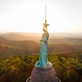 Das imposante Hermannsdenkmal ragt bei Sonnenuntergang über die bewaldete Landschaft des Teutoburger Waldes.