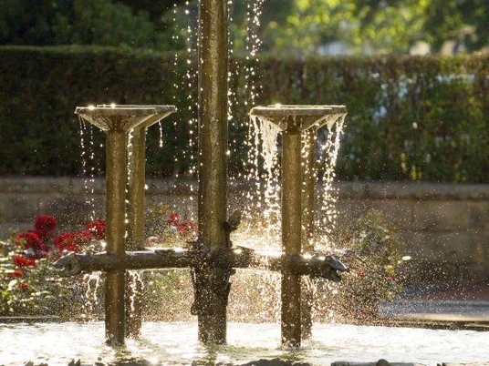 Nahaufnahme von dem Dreizehnlindenbrunnen mit Blumen in Bad Driburg.