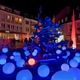 Leuchtende Kugeln umgeben den Neptunbrunnen in Paderborn bei Nacht, stimmungsvoll illuminiert.