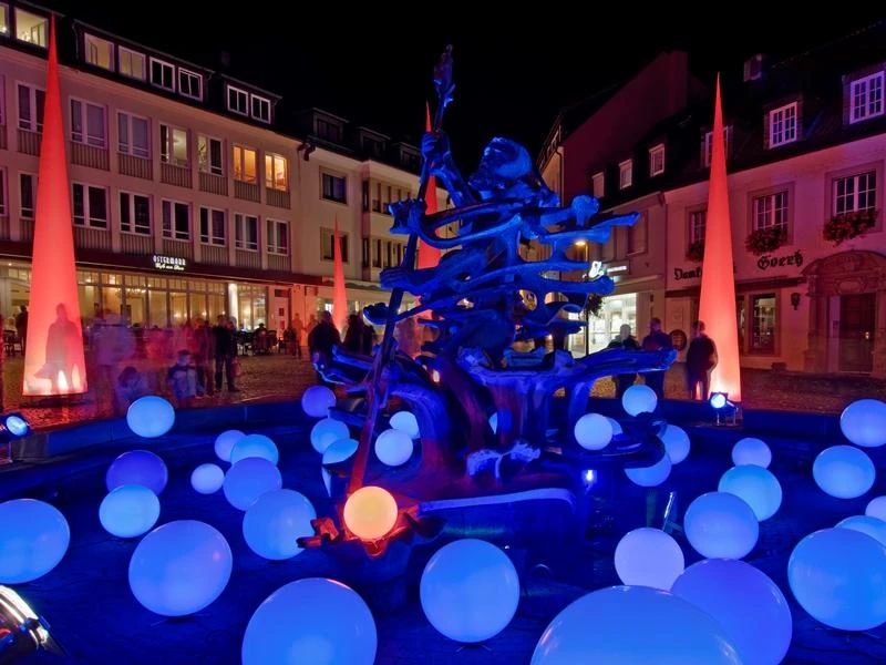 Neptunbrunnen Paderborn Leuchtende Kugeln umgeben den Neptunbrunnen in Paderborn bei Nacht, stimmungsvoll illuminiert.