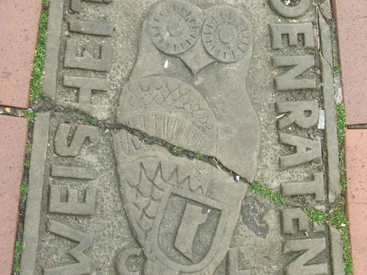 Steinboden mit einer stilisierten Eule und den Inschriften "WEISHEIT" und "DEN RATEN".