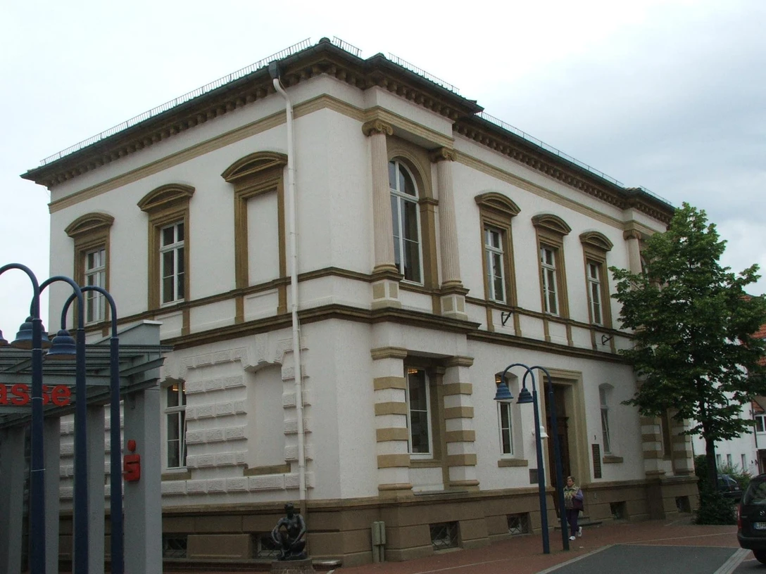 Historisches Gebäude aus dem 19. Jahrhundert mit hoher Fassade, großen Fenstern und Sandsteinelementen.