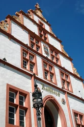 Historisches Rathaus Schmuckfassade Eine prächtige Fassade des historischen Rathauses mit rotem und weißem Spitzgiebel, verziert mit Wappen.