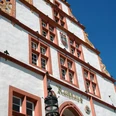 Historisches Rathaus Schmuckfassade Eine prächtige Fassade des historischen Rathauses mit rotem und weißem Spitzgiebel, verziert mit Wappen.
