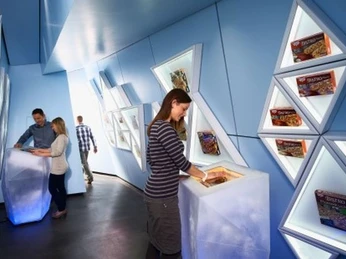 Dr. Oetker Welt II Betriebsführung in moderner Ausstellung mit beleuchteten Plakaten von Dr. Oetker Backprodukten.