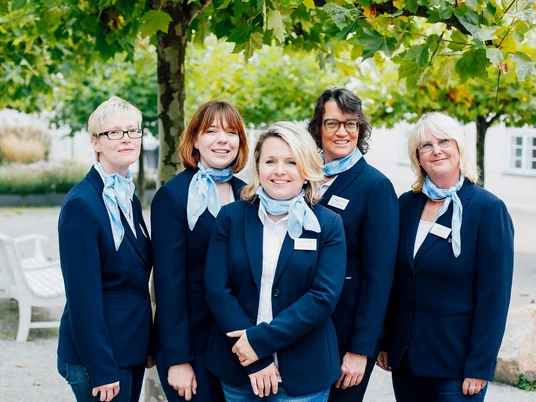 Staatsbad Salzuflen - Service Team Tourist Informationen Fünf Frauen aus dem Service-Team der Tourist-Information Bad Salzuflen unter grünen Bäumen.