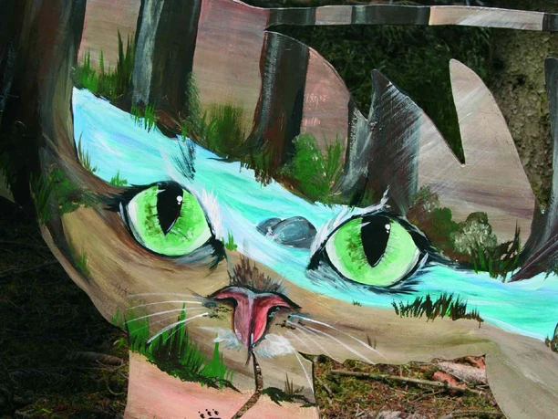 Katzen-Augen-Blicke Ein Gemälde einer Katze mit auffällig grünen Augen, umgeben von Naturmotiven, auf Holzhintergrund.