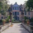 Gutshof Engershausen Historisches Herrenhaus mit gelber Fassade, symmetrischen Fenstern und Natursteinsäulen vor dem Eingang.
