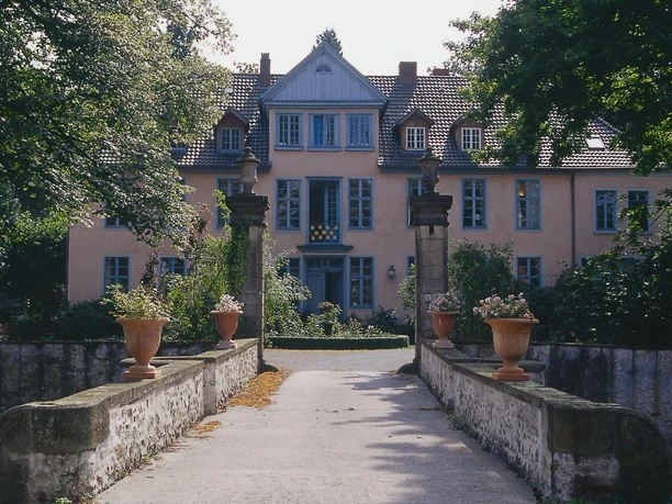 Gutshof Engershausen Historisches Herrenhaus mit gelber Fassade, symmetrischen Fenstern und Natursteinsäulen vor dem Eingang.