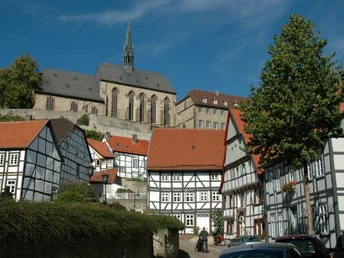 Altstadtblick Fachwerkhäuser reihen sich aneinander mit einem markanten Kirchturm im Hintergrund unter blauem Himmel.