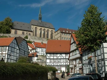Altstadtblick Fachwerkhäuser reihen sich aneinander mit einem markanten Kirchturm im Hintergrund unter blauem Himmel.