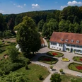 Kurpark Bad Holzhausen Historisches Herrenhaus im Kurpark Bad Holzhausen, umgeben von gepflegten Gärten und Waldkulisse.