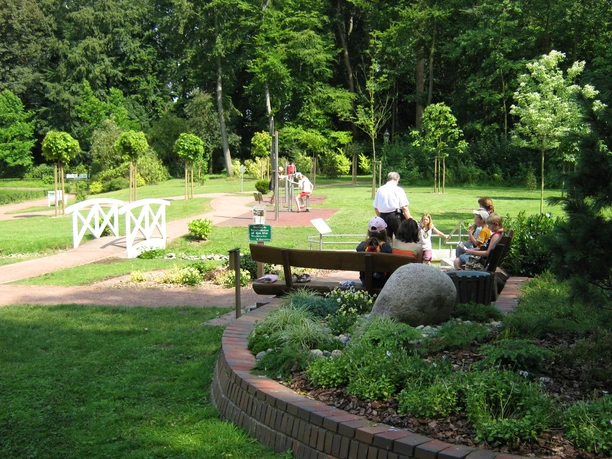 Rastplatz am Garten der Generationen Ruhiger Rastplatz im Grünen, umgeben von Bäumen und Pflanzen, mit Sitzgelegenheiten für Besucher.