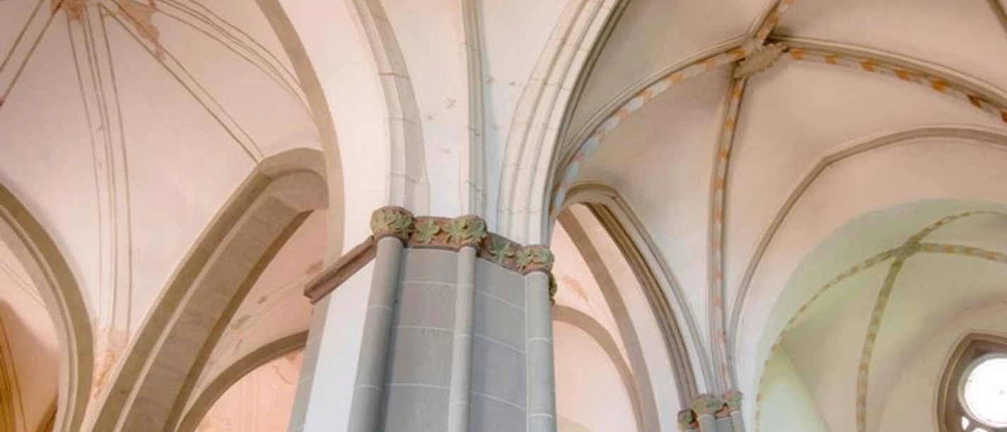Gewölbte gotische Decken mit verzierten Säulen im Inneren des ehemaligen Dominikanerklosters Warburg.