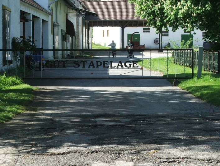 Eingangstor des historischen Gut Stapelage mit dahinterliegenden landwirtschaftlichen Gebäuden.