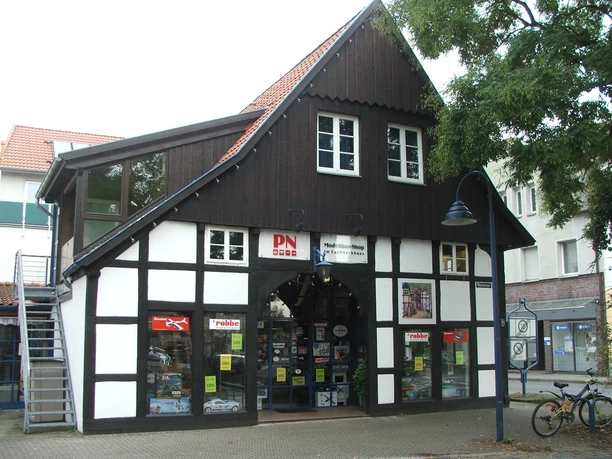 Fachwerkhaus Rhienstraße 39 Fachwerkhaus mit schwarzem Holz und weißen Wänden, im Erdgeschoss Geschäfte mit Modellbauartikeln.