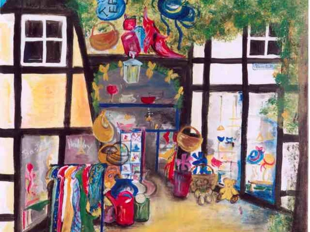 Farbintensives Fachwerkhaus mit buntem Schaufenster. Bekleidung und Haushaltswaren an der Front.