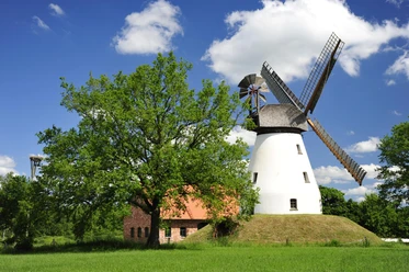 Windmühle Heimsen Historische Windmühle Heimsen umgeben von grüner Wiese und blauem Himmel mit weißen Wolken.