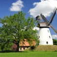 Windmühle Heimsen Historische Windmühle Heimsen umgeben von grüner Wiese und blauem Himmel mit weißen Wolken.
