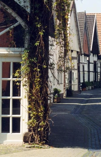 Historische Fachwerkhäuser säumen eine gepflasterte Gasse in der Altstadt von Rheda.