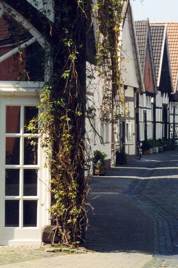 Historische Fachwerkhäuser säumen eine gepflasterte Gasse in der Altstadt von Rheda.