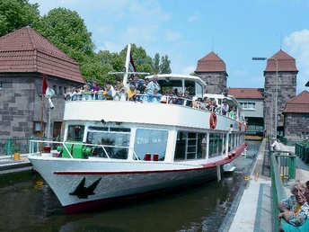 Mindener Fahrgastschiffahrt Das Bild zeigt ein Schiff, das aus der Schachtschleuse fährt.