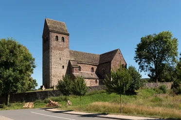 St. Kilianskirche Lügde St. Kilianskirche in Lügde aus Bruchstein, umgeben von Bäumen; quadratischer Kirchturm, blauer Himmel.